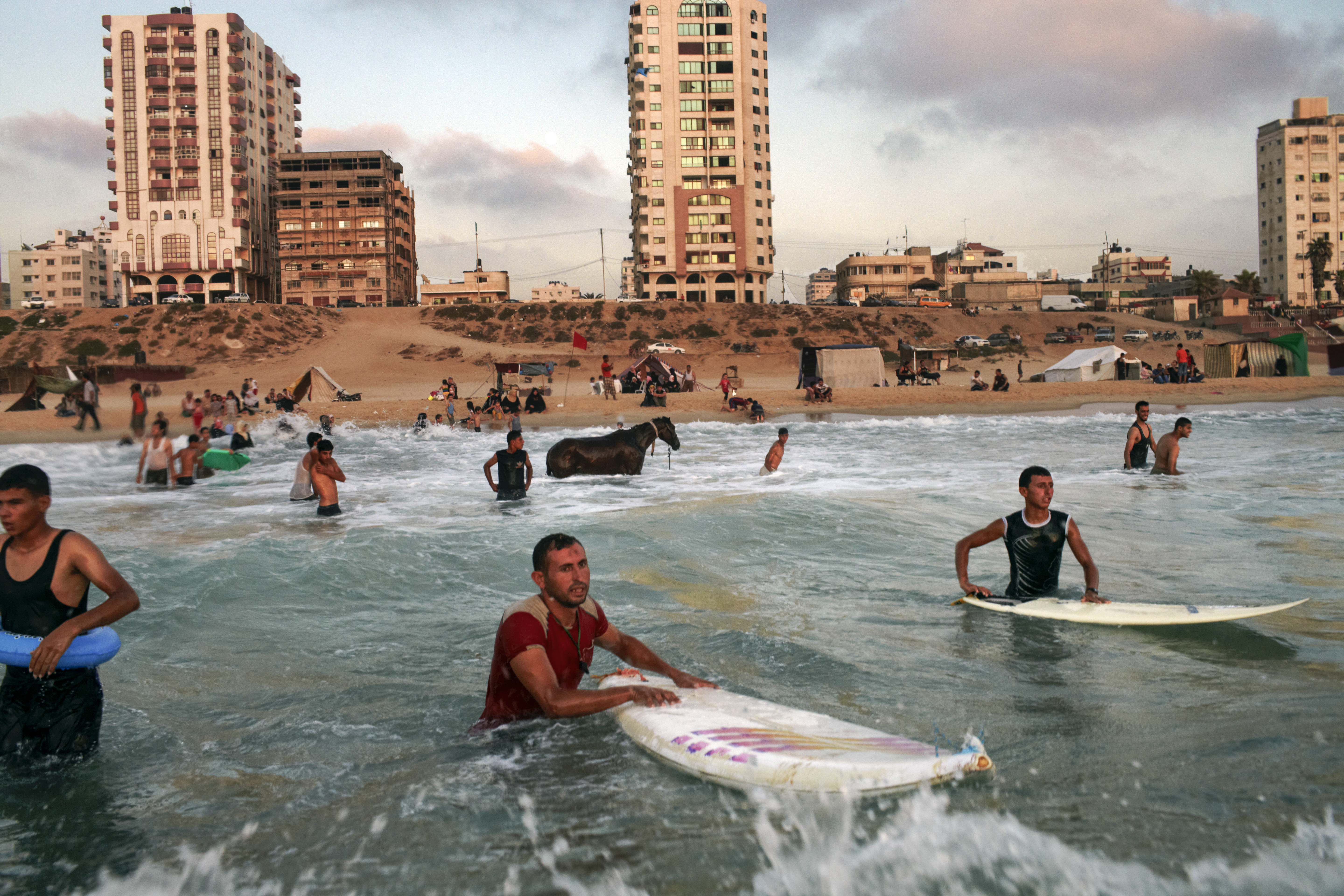 Still from the film Gaza shows Palestinian men surfing in the sea.