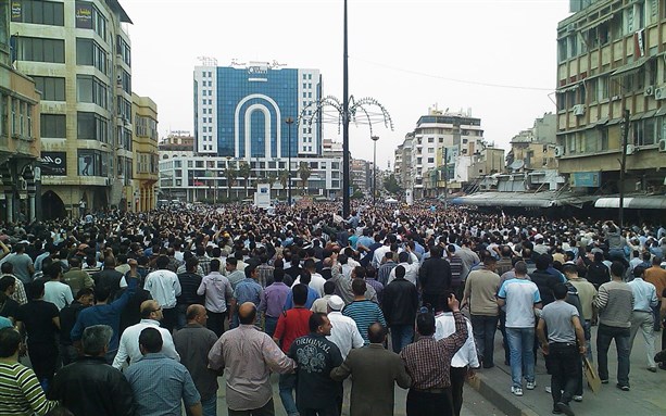 [Large demonstration in Homs, Syria against the Syrian regime. Image from WikiMedia Commons.]