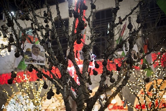 [Tear gas canisters, shot by the Israeli army during protest in the West Bank, are displayed on a tree during Christmas eve celebrations outside the Church of the Nativity, Bethlehem, 24 December 2014. Image by Activestills, via Flickr.]