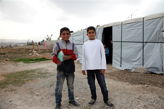 Muhanad and Ahmad*, two Syrian refugee boys outside Ahmad's temporary home, in Lebanon's Bekaa Valley. Via Wikimedia Commons.