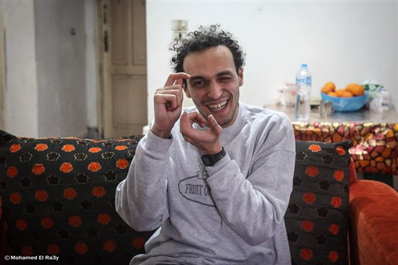 Egyptian photojournalist Mahmoud Abu Zeid, also known as 'Shawkan', gestures inside his home after being released, in Cairo, 4 March 2019 (Via Mohamed El Raai/ AFP)
