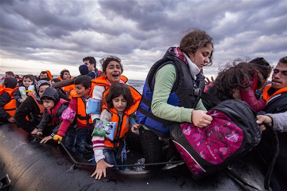 Syrian refugees arrive from Turkey on a boat through sea near Molyvos, Lesbos. Image by Nicolas Economou via Shutterstock.