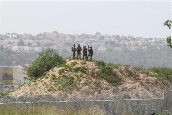 Israeli soldiers stand guard during a regular protest in Bilin, West Bank, Palestine, 15 February 2019. Image via Shutterstock.