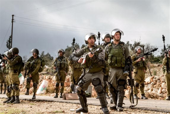 Bilin, Palestine, 31 December 2010: Israel Defence Force soldier is holding tear gas canisters during weekly demonstrations against Palestinian land confiscation.