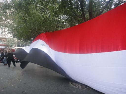 [Syrian flag at protest held in Paris in honor of Mashaal Tammo. This and all other images in this post by Amal Hannano.]