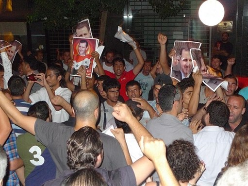 [Counter-protesters in Hamra holding pictures of Bashar al-Asad.]