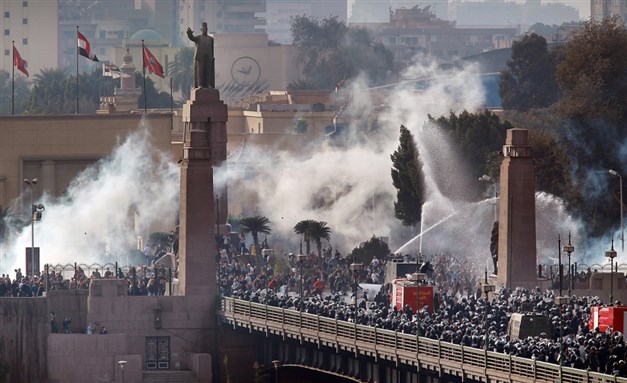 Riot police force protesters back across the Kasr al-Nile bridge. Photo via Getty Images