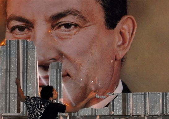  An anti-government protester defaces a picture of Egypt's President Hosni Mubarak on January 25, 2011. (via Reuters)