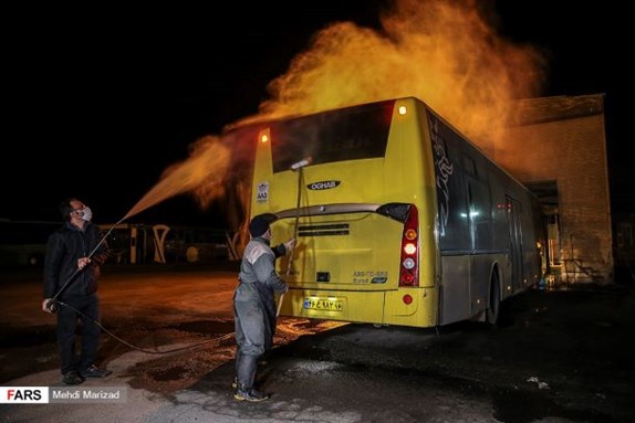 Workers disinfect a bus to fight the coronavirus. Image from Mehdi Marizad via Wikimedia Commons.