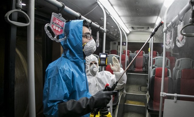 Workers disinfecting public transport in Tabriz. Image from Mehr News Agency via Wikimedia Commons.