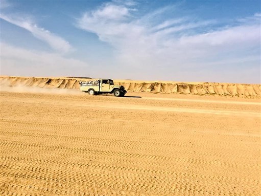 Photographie de l'auteur. Véhicule longent le mur de sable El Pipe pour tenter de traverser la frontière.