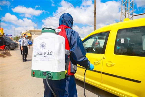 Qalqilya, Palestinian Territories, Palestine, July 1, 2020. Disinfectant worker in protective suits with mask. sprayes disinfectant in the street to prevent the spread of coronavirus (Covid-19). Photo by abu adel - photo via Shutterstock.