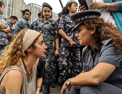 A protester faces off with a police officer during a sit-in on a main road in the Lebanese capital of Beirut, on the tenth day of anti-government demonstrations (Beirut, Lebanon, 10 October 2019). Photo by RichInBeirut via Shutterstock.