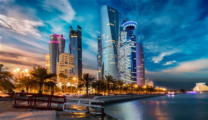 The skyline of Doha city center after sunset, Qatar via Shutterstock