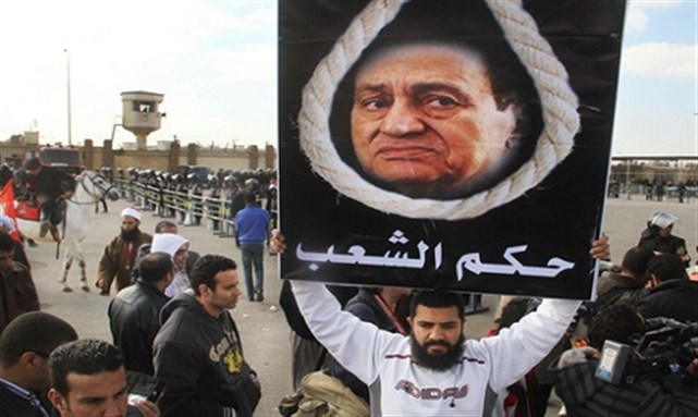 [Protester outside Mubarak trial. Image from Reuters]