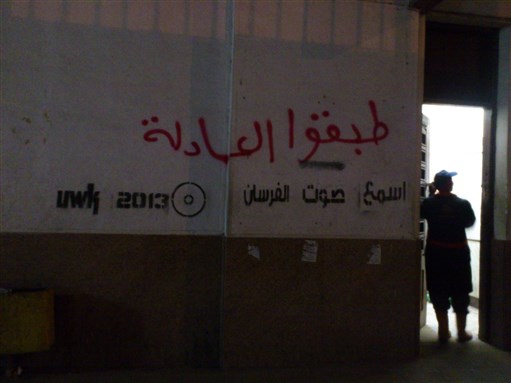 [A (misspelled) message on the wall in a Cairo metro station: \"implement justice.\" Photo by Philip Rizk]