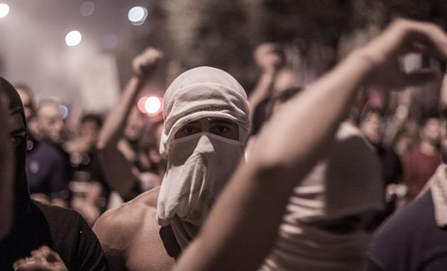[Protester in downtown Beirut, wearing his shirt on his face to protect himself from tear gas fired by security forces. Image by Victor Choueiri, via Flickr.]