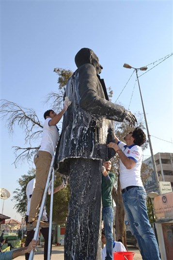 [Youth washing Sayyab`s statue in Basra, image from pukmedia.com]