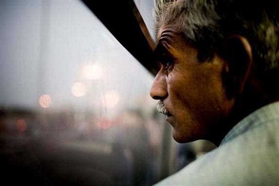 [Workers in a bus after a day of work in Dubai. Image from Flickr/Eric J Scott]
