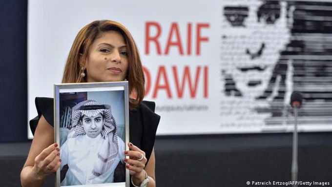 Raif Badawi's wife holding a picture of him via Getty Images/AFP from Patreich Eretzog