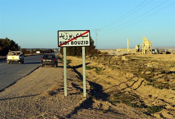 [A car drives past a road sign in Sidi Bouzid. Photo Credit: Getty Images.]