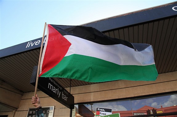 [Palestinian flag waves at a pro-BDS event in Victoria, Australia, September 10 2011. Image by Kate Ausburn.]