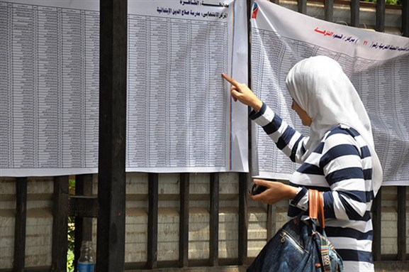 [A woman checking her name in the elections list at a voting station in Cairo. Image originally posted to Flickr by UN Women Arab States.]