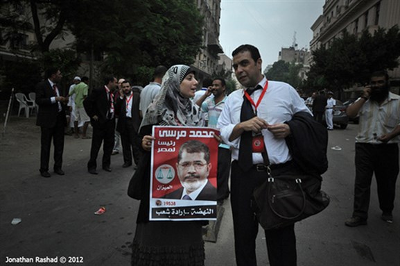 [A woman holds a picture of President Morsi in the streets of Tahrir, Cairo. Image originally posted to Flickr by Johnathan Rashad.]
