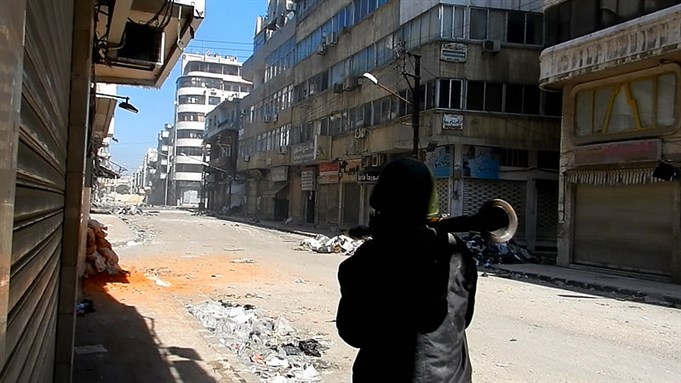 [A Free Syrian Army fighter prepares to fire an RPG on regime forces in Homs, Syria. Image from Wikimedia Commons.]