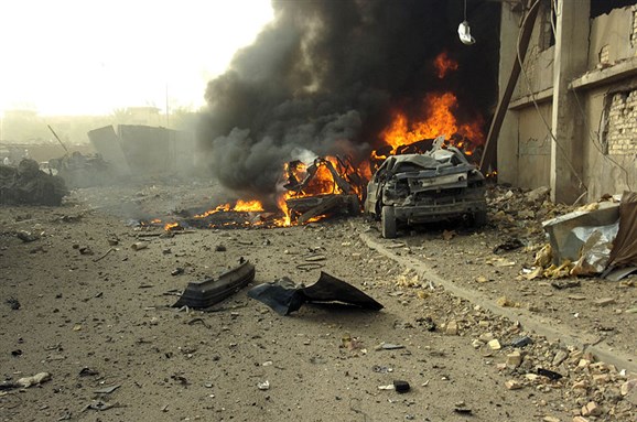 [A Vehicle Born Improvised Explosive Devise (VBIED) after exploding on a street outside of the Al Sabah newspaper office in the Waziryia district of Baghdad, Iraq. Image by Eli J. Medellin.]