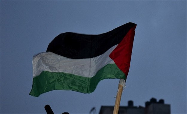 [Crop of image of Palestinian flag, held by a protester in Ramallah. Image by Tony Kane.]