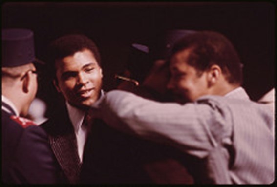 [World Heavyweight Boxing Champion Muhammad Ali attends The Sect`s Service to Hear Elijah Muhammad deliver The Annual Savior`s Day Message in Chicago in March 1974. Image via the US National Archives]