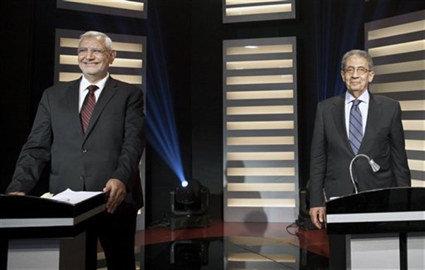 [Abdel-Moneim Abolfotoh, left, and Amr Moussa stand at their podiums on Egypt`s first televised presidential debate. Cairo, May 11, 2012. Image by Mahmoud Khaled, Al Masry Al Youm/AP Photo.]