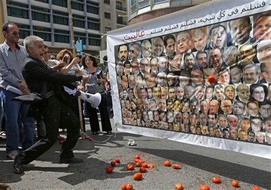 [In this 31 May2013 file photo, a Lebanese protester throws tomatoes at a banner with the portraits of the 128 Lebanese lawmakers with Arabic that reads, \"you failed in everything, failed failed failed, go home,\" during a protest against the seventeen months extension of the Lebanese parliament, near the parliament building in Beirut, Lebanon. Image by Hussein Malla via Associated Press]