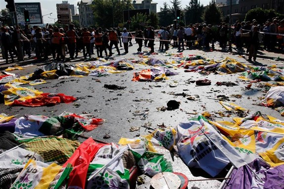 [Bodies covered with flags in the aftermath of the explosions at a peace rally in Ankara on October 10. Image by Fatih Pinar.]