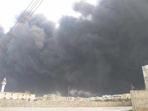 [A dark cloud of smoke hovers over Homs. Courtesy of Omar Shakir.]
