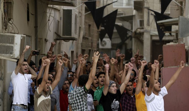 [Anti-government protesters in Bahrain chant against the police on April 19, 2012. Hasan Jamali/AP]