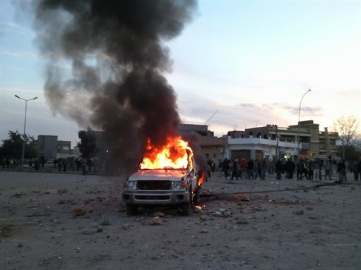[Burning vehicle in Bayda on 16 February 2011. Image from Wikipedia.]