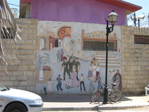 [A mural depicting Israeli settlements in Hebron. Image from Wikimedia Commons.]