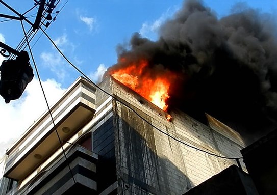 [A burning house in Homs following an attack by the Syrian army. Image from Wikimedia Commons.]