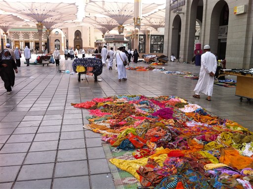 [Vendors selling their colorful textiles in front of the Prophet`s Mosque in Madina. Image by Rosie Bsheer]