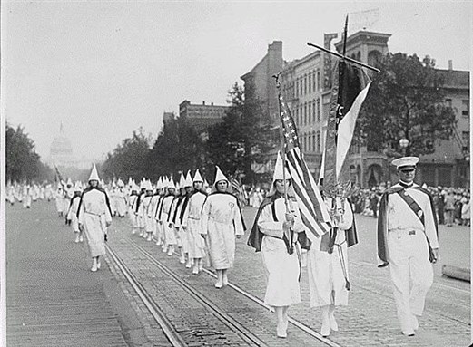 [Ku Klux Klan members march down Pennsylvania Avenue in Washington in 1928. Image via National Archives and Records Administration]