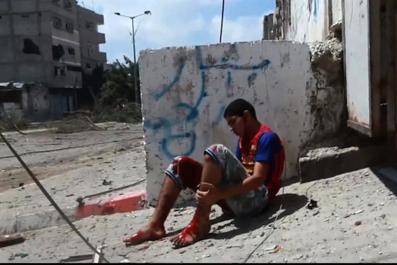 [A bloodied man in Shuja-iyya, Palestine. Image by ???? ?????????.]
