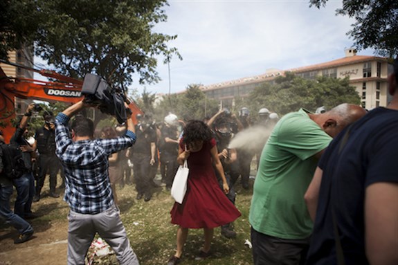 [28 May 2013. Police use tear gas to disperse a group who are standing guard in Istanbul`s Gezi Park in an attempt to prevent the Istanbul Metropolitan Municipality from demolishing the last remaining green public space in the center of the city. Photo by Tolga Sezgin/Nar Photos.]