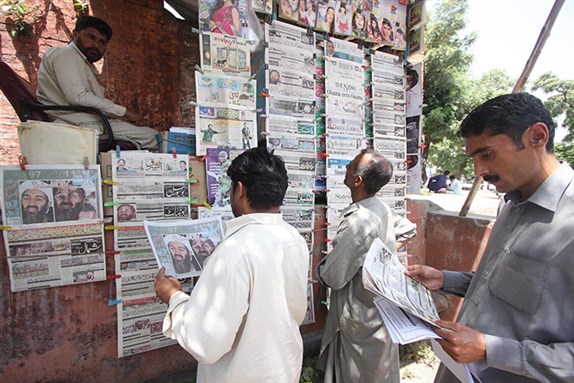 [Pakistani men reading papers about Osama bin Laden`s killing. Image from T Mughal/EPA]