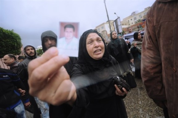[A mother of one of the twenty-one football fans sentenced to death in the 1 February 2012 Port Said stadium-riot case, yelling at media \"does my son look like a thug?\" Photo by Jonathan Rashad]