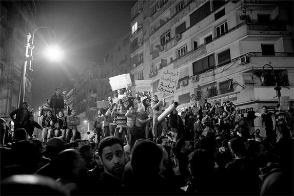 [Protesters standing on a tank in Tahrir Square. Image from Hossam El-Hamalawy Archive.]