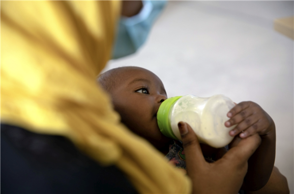 A refugee feeds her baby while waiting to receive assistance at an emergency distribution by UNHCR and partners in Tripoli, Libya.  © UNHCR/Mohamed Alalem