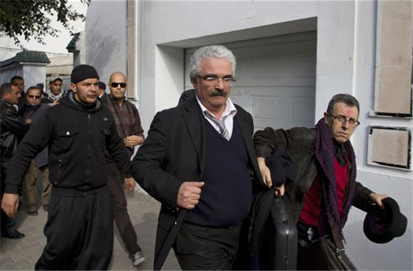 [Zied Krichen, 2nd right, editor of the newspaper \"The Maghreb\", and Hamadi Redissi, right, President of the Tunisian Observatory for a Democratic Transition, are chased by Tunisian Salafi muslims as they leave the Tunis courthouse after attending the trial of Nabil Karoui, the owner of a Tunisian private channel, Nessma TV, Jan. 23, 2012. Nearly 140 lawyers filed lawsuits against Karoui for `violating sacred values` and `disturbing public order` after his station broadcast a version of the French-Iranian film Persepolis dubbed in Tunisian dialect. Image by Amine Landoulsi/AP Photo.]