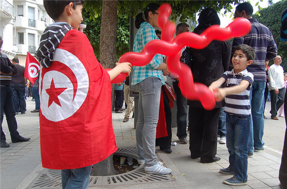 [Young children play during the 1 May 2012 march in Tunis, Tunisia. Image by scossargilbert/Flickr.]